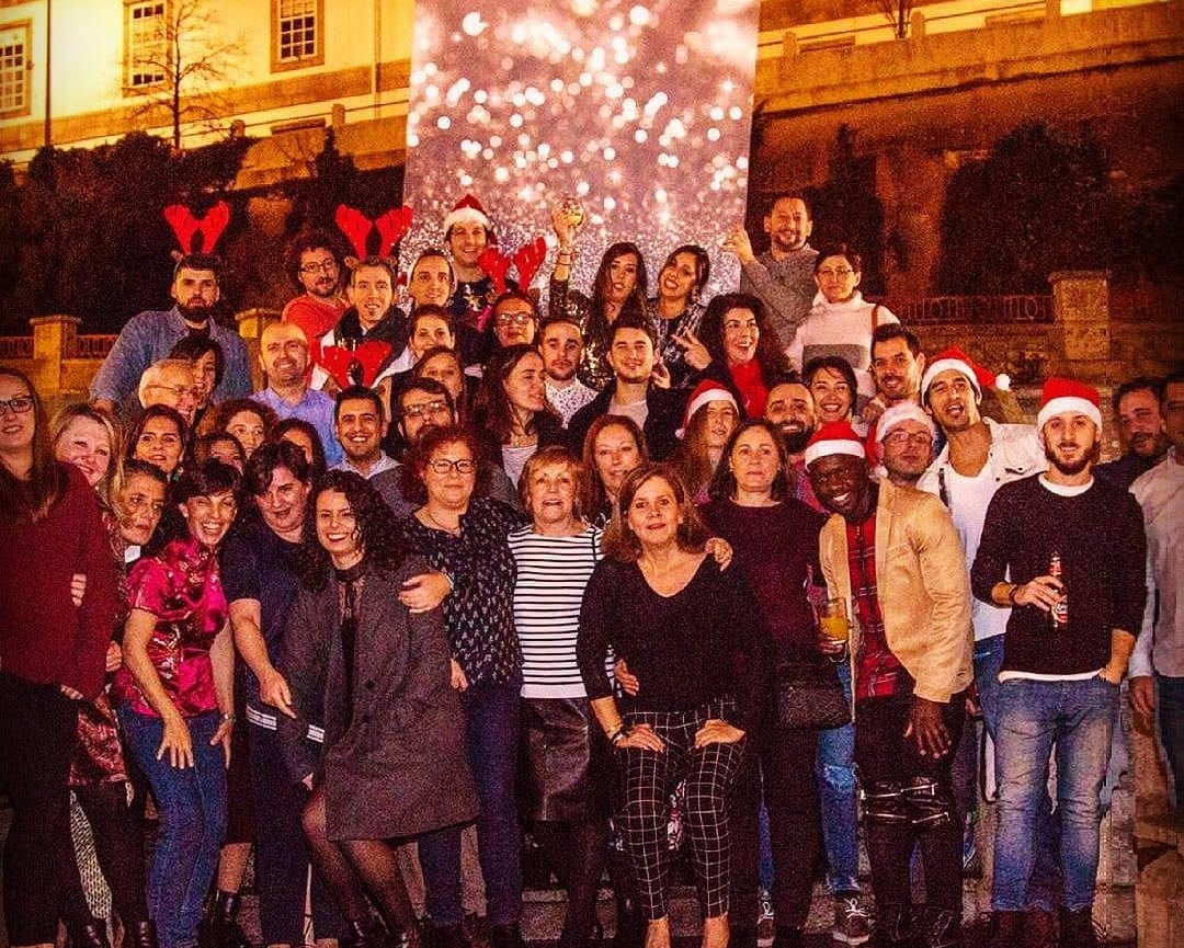 Un grupo de empresa con gorros de Papá Noel y cuernos de reno celebrando su fiesta de Navidad