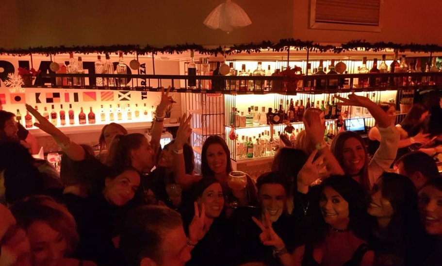 Grupo celebrando la Navidad en Rialto con guirnaldas en la barra