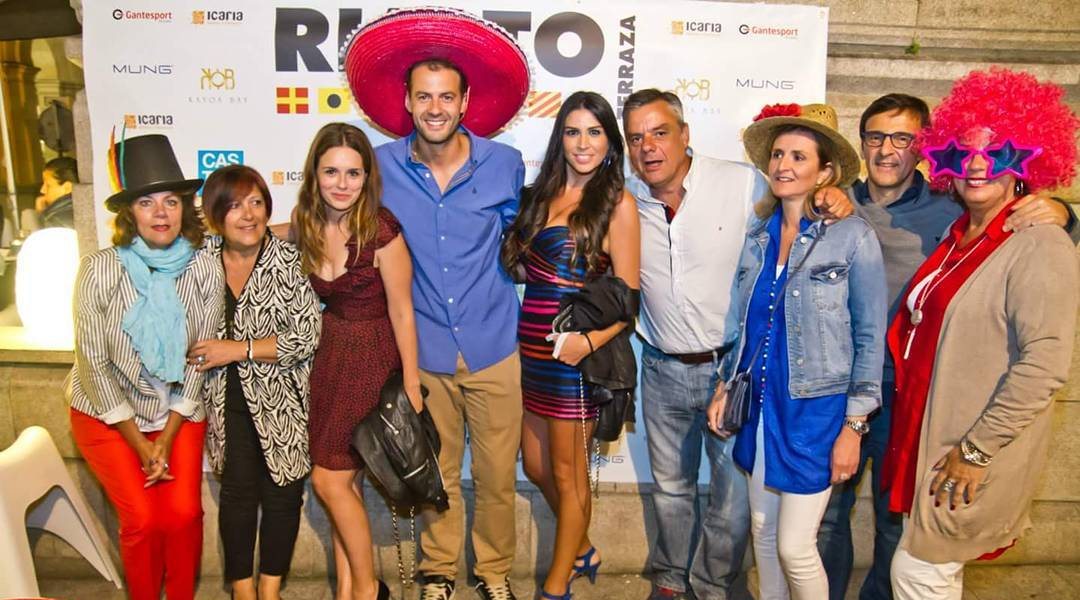 Invitados con sombreros y pelucas posando en el photocall de un evento en Rialto
